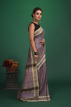 Shop this exquisite lavender purple tussar saree with purple vidharbha border online in USA which is handcrafted from fine silk tussar fabric, this tie and dye saree brings out the nature of flow. This tussar saree with elegant purple Vidharbha border is making everyone swoon over it. Make it yours and flaunt a handwoven marvel with minimal jewellery for a casual day outfit. Add this pure tussar saree to your collection from Pure Elegance Indian fashion store in USA.-Side view.