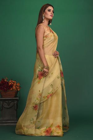 Buy this royal handcrafted weaving saree in cotton silk in light yellow color online in USA. It also has a Pallu with bronze weave and fringes. The entire saree has a Golden border and enhance with a beautiful floral pattern.  Make it yours and flaunt a handwoven marvel with minimal jewellery for a casual day outfit. Add this coton silk saree to your collection from Pure Elegance Indian fashion store in USA.-Side view.