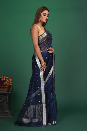 Buy this elegant dark blue soft organza designer saree with silver zari work on heavy border online in USA. Organza silk fabric is a type of silk cloth that is crisp, translucent, and extremely light in weight. It is used to make organza silk saree, drapes, and other decorative pieces. Add this designer sari to your collection from Pure Elegance Indian fashion store in USA..-Side view.