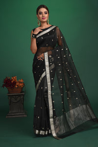 Buy this elegant black soft organza designer saree with silver zari work on heavy border online in USA. Organza silk fabric is a type of silk cloth that is crisp, translucent, and extremely light in weight. It is used to make organza silk saree, drapes, and other decorative pieces. Add this designer sari to your collection from Pure Elegance Indian fashion store in USA.-Full view with open pallu.