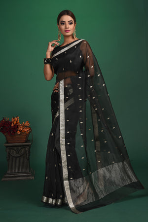 Buy this elegant black soft organza designer saree with silver zari work on heavy border online in USA. Organza silk fabric is a type of silk cloth that is crisp, translucent, and extremely light in weight. It is used to make organza silk saree, drapes, and other decorative pieces. Add this designer sari to your collection from Pure Elegance Indian fashion store in USA.-Full view.
