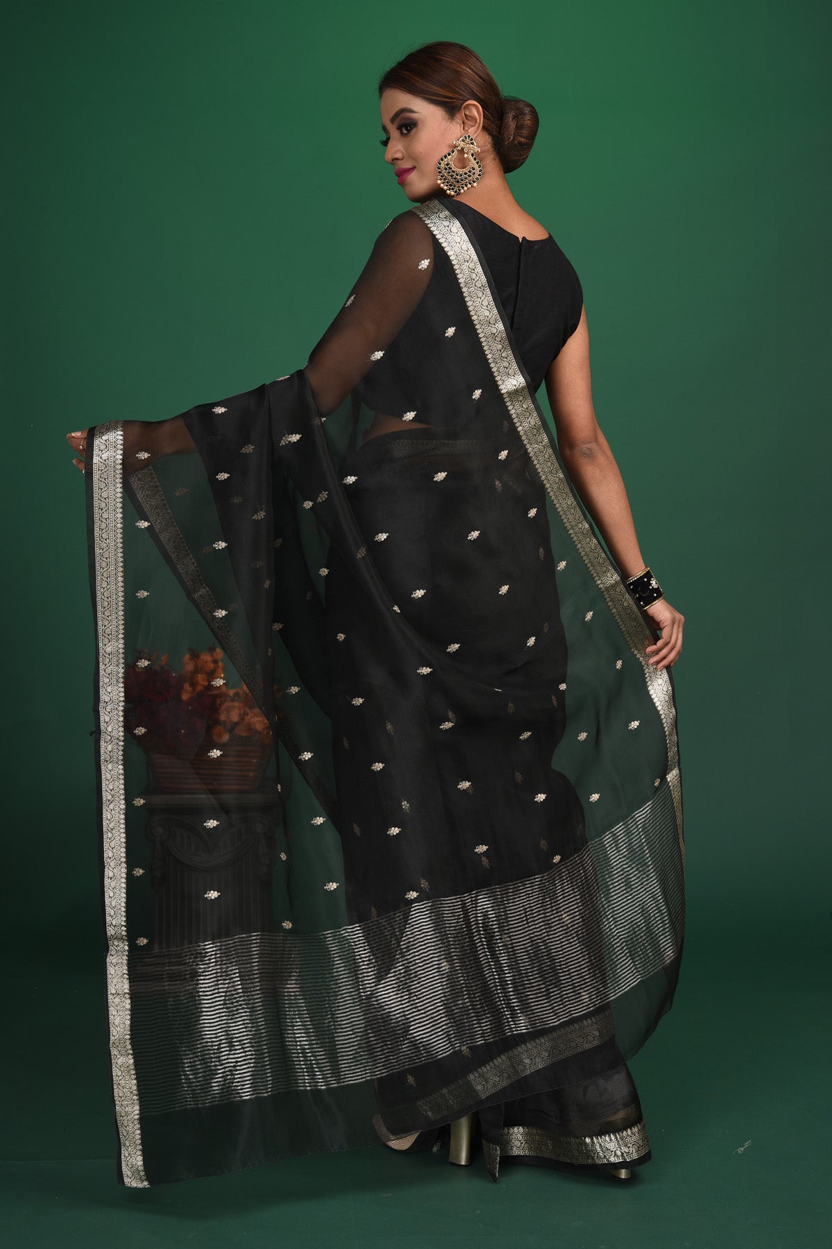 Buy this elegant black soft organza designer saree with silver zari work on heavy border online in USA. Organza silk fabric is a type of silk cloth that is crisp, translucent, and extremely light in weight. It is used to make organza silk saree, drapes, and other decorative pieces. Add this designer sari to your collection from Pure Elegance Indian fashion store in USA.-Back view with open pallu.