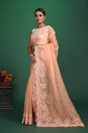 Shop this exquisite peach saree in soft organza with heavy lace border online in USA which is made of organza fabric and lightweight. This organza Saree is beautified with lace work and latest trend. Ideal for casual, kitty parties, stylish accessories. Shop this from Pure Elegance Indian fashion store in USA.-Side view with open pallu.
