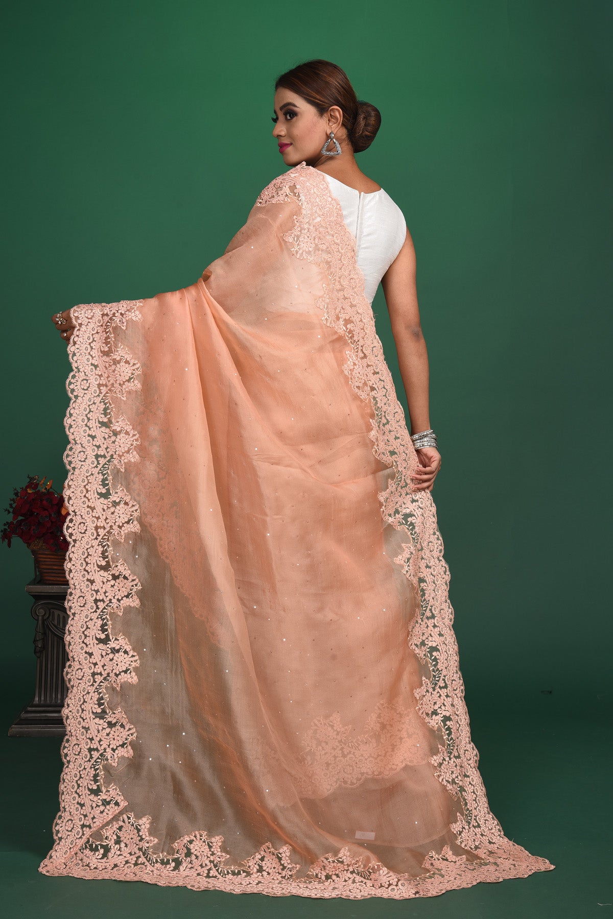 Shop this exquisite peach saree in soft organza with heavy lace border online in USA which is made of organza fabric and lightweight. This organza Saree is beautified with lace work and latest trend. Ideal for casual, kitty parties, stylish accessories. Shop this from Pure Elegance Indian fashion store in USA.-Back view with open pallu.