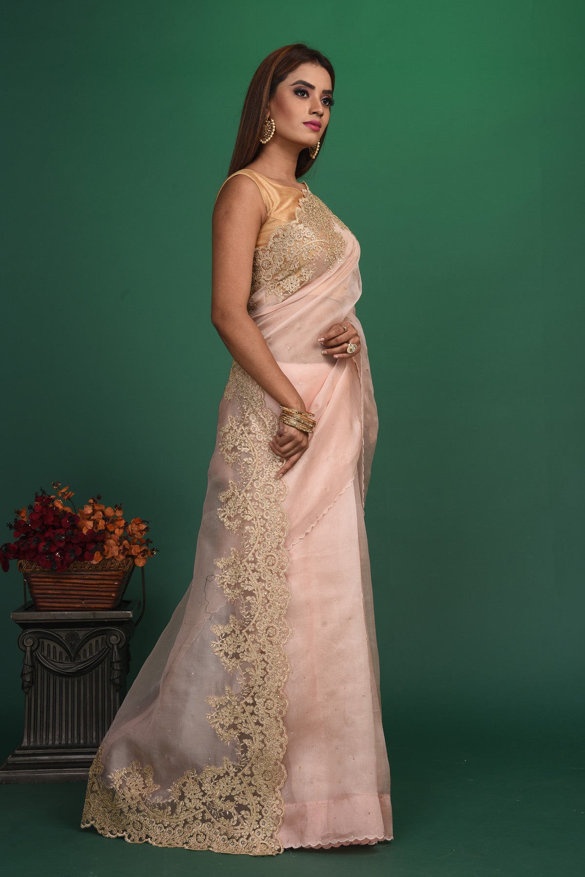 Buy this elegant baby pink designer saree in soft organza with heavy golden embroidered border online in USA which is made of organza fabric and lightweight. This organza Saree is beautified with embroidered work and latest trend. Ideal for casual, kitty parties, stylish accessories. Shop this from Pure Elegance Indian fashion store in USA.-Side view.