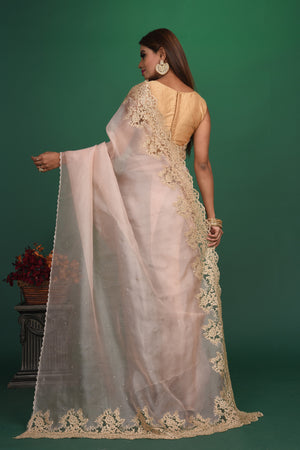 Buy this elegant baby pink designer saree in soft organza with heavy golden embroidered border online in USA which is made of organza fabric and lightweight. This organza Saree is beautified with embroidered work and latest trend. Ideal for casual, kitty parties, stylish accessories. Shop this from Pure Elegance Indian fashion store in USA.-Back view with open pallu.