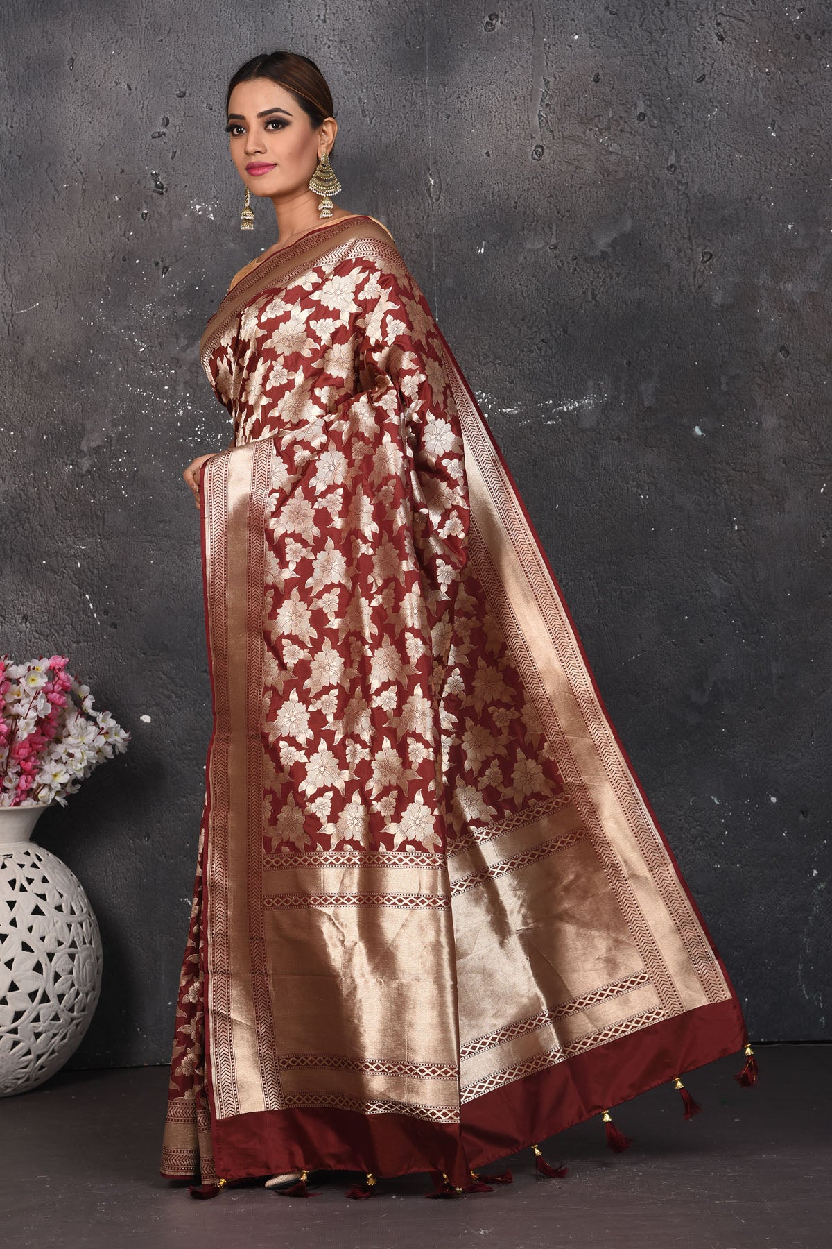 Shop this ethnic deep maroon banarasi silk saree online in USA with zari work which is crafted with  heavy golden zari beautified border. A Beautiful Handloom Banarasi Saree adorned with amazing floral pattern and by skilled weaver of Banaras with elegance and grace, this saree is definitely the epitome of beauty. Style this banarasi silk saree from Pure Elegance Indian fashion store in USA.- Side view with open pallu.