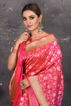 Shop thos elegant pink woven banarasi silk saree with golden zari work online in USA. With exquisite design spread across the length of the saree, it is perfect for any occasion which has a beautiful floral pattern zari work with blend of gold colour. Pair this silk banarasi silk sari with heels and a moti necklace from Pure Elegance Indian fashion store in USA.- Close up.