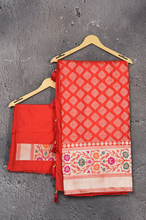 Shop this exquisite coral red silk brocade handloom banarasi saree online in USA. The sari comes with a graceful border with handmade latkan and colourful floral pattern all over. Buy this brocade banarsi sari with zari work from Pure Elegance Indian fashion store in USA and style it with your best pair of heels, gold or Moti necklace and a potli bag for the perfect look.- Unstitched blouse.
