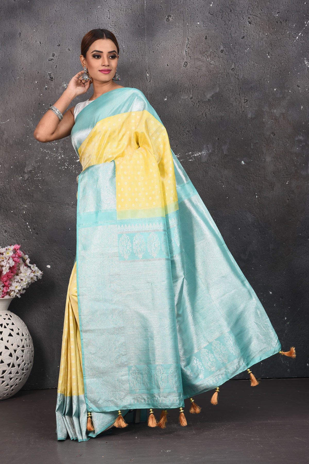Shop this royal handwoven pure kanchiresham saree in lemon yellow with a firozi blue pallu and buti work online in USA. Presenting Enchanting Yet Breathable Organic Banarasi Saree Made from Kanjivaram silk. Drape yourself in this beautiful banarasi saree from Pure Elegance Indian Fashion Store in USA with Zari woven Border with a potli bag and high heels for a flawless look.- Full view with open pallu.