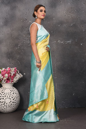Shop this royal handwoven pure kanchiresham saree in lemon yellow with a firozi blue pallu and buti work online in USA. Presenting Enchanting Yet Breathable Organic Banarasi Saree Made from Kanjivaram silk. Drape yourself in this beautiful banarasi saree from Pure Elegance Indian Fashion Store in USA with Zari woven Border with a potli bag and high heels for a flawless look.- Side view.
