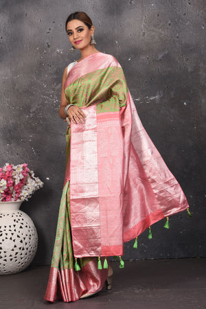 Buy this royal olive green-pink handloom kanchipuram saree with buta zari work online in USA. An enchanting silk saree with scintillating palla and border. This kanchipuram silk brings the charm and simplicity of this olive green saree with border and pallu with the delegate buta work with silver zari. Shop this designer silk sari from Pure Elegance Indian fashion store in USA.- Full view with open pallu.