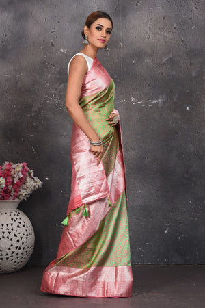 Buy this royal olive green-pink handloom kanchipuram saree with buta zari work online in USA. An enchanting silk saree with scintillating palla and border. This kanchipuram silk brings the charm and simplicity of this olive green saree with border and pallu with the delegate buta work with silver zari. Shop this designer silk sari from Pure Elegance Indian fashion store in USA.- Side view.