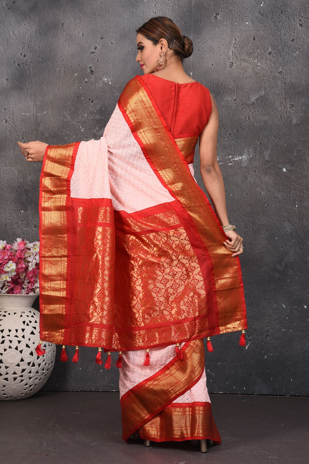 Shop this elegant peach pink sequins georgette saree with red-golden zari border online in USA. Create and establish a smashing influence on everybody by carrying this designer sequin georgette saree with your designer blouse. Shop designer sequins georgette with heavy border from Pure Elegance Indian saree store in USA.- Back view with open pallu.