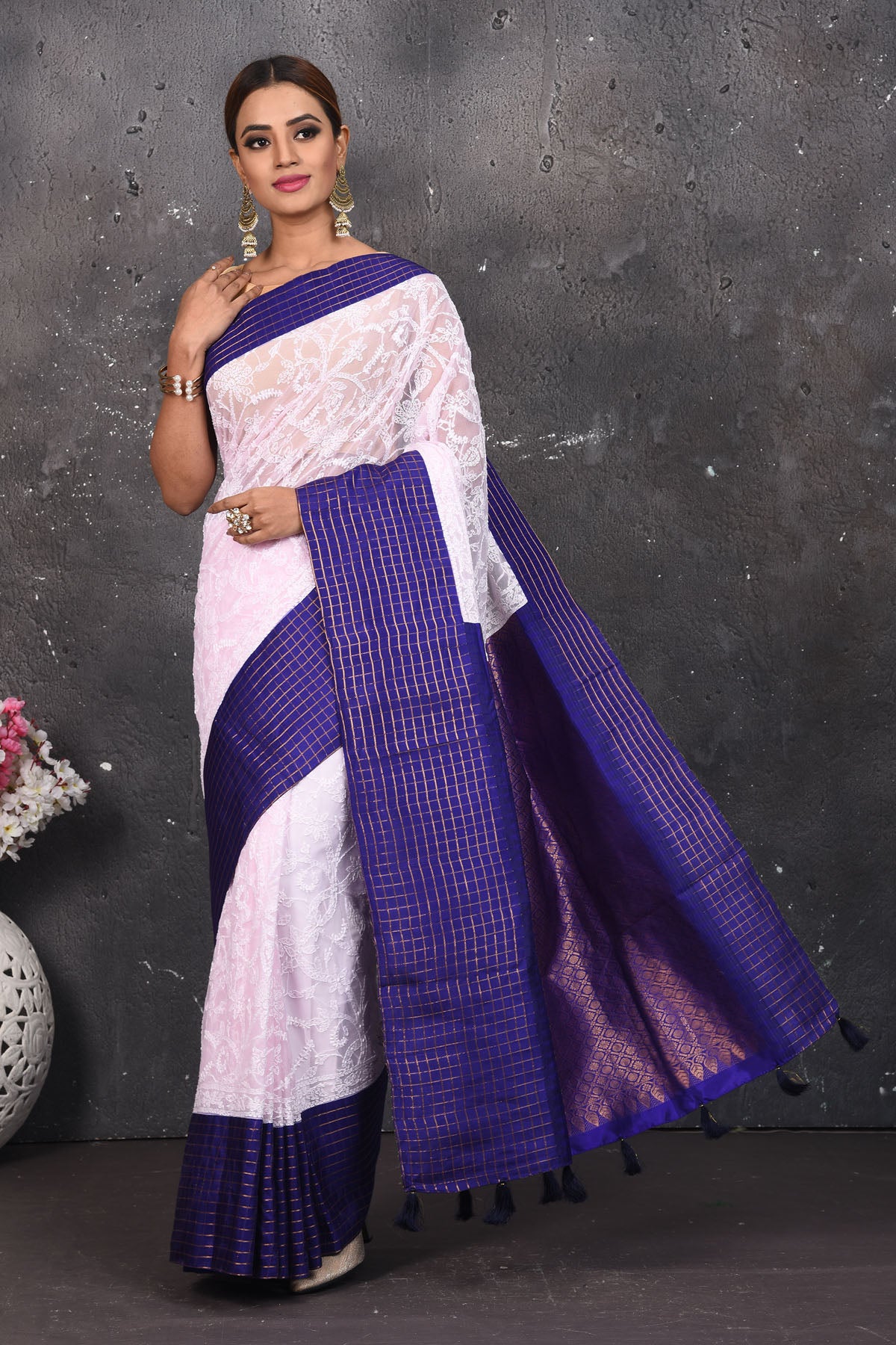 Buy this exquisite Off-white and violet chiffon saree with chikankari hand-embroidered online in USA. Style this lucknawi sari with a potli bag and high heels for a flawless look which has gorgeous heavy pallu with dull-gold zari work. This saree is definitely the epitome of beauty and a must have in your collection. Buy designer handwoven chikankari sari with any blouse from Pure Elegance Indian saree store in USA.- Full view.
