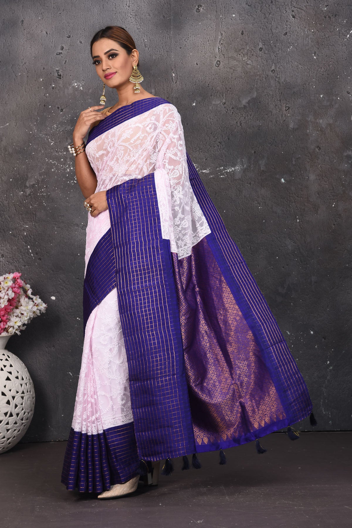 Buy this exquisite Off-white and violet chiffon saree with chikankari hand-embroidered online in USA. Style this lucknawi sari with a potli bag and high heels for a flawless look which has gorgeous heavy pallu with dull-gold zari work. This saree is definitely the epitome of beauty and a must have in your collection. Buy designer handwoven chikankari sari with any blouse from Pure Elegance Indian saree store in USA.- Full view with open pallu.