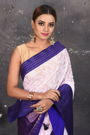 Buy this exquisite Off-white and violet chiffon saree with chikankari hand-embroidered online in USA. Style this lucknawi sari with a potli bag and high heels for a flawless look which has gorgeous heavy pallu with dull-gold zari work. This saree is definitely the epitome of beauty and a must have in your collection. Buy designer handwoven chikankari sari with any blouse from Pure Elegance Indian saree store in USA.- Close up.