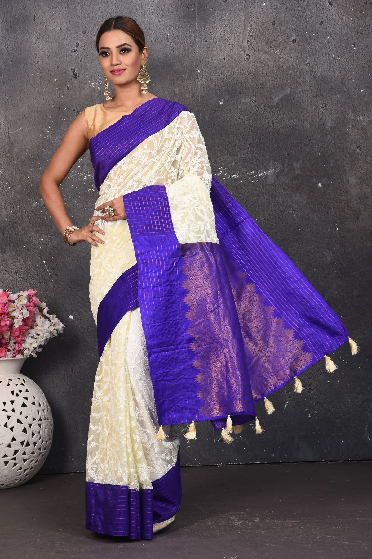 Buy this exquisite Off-white and violet chiffon box printed saree with chikankari hand-embroidered online in USA. Style this lucknawi sari with a potli bag and high heels for a flawless look which has gorgeous heavy pallu with dull-gold zari work. This saree is definitely the epitome of beauty and a must have in your collection. Buy designer handwoven chikankari sari with any blouse from Pure Elegance Indian saree store in USA.- Full view with open pallu.