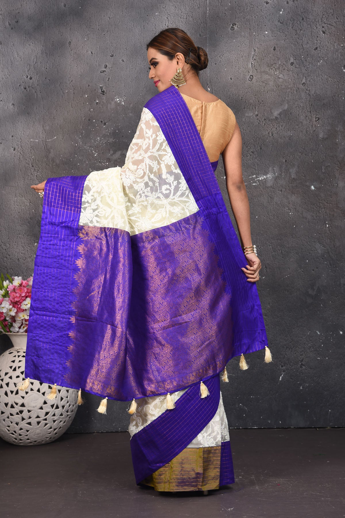 Buy this exquisite Off-white and violet chiffon box printed saree with chikankari hand-embroidered online in USA. Style this lucknawi sari with a potli bag and high heels for a flawless look which has gorgeous heavy pallu with dull-gold zari work. This saree is definitely the epitome of beauty and a must have in your collection. Buy designer handwoven chikankari sari with any blouse from Pure Elegance Indian saree store in USA.- Back view with open pallu.