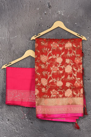 Buy this dazzling red kora silk handloom banarasi saree adorned with stunning resham and intricate Meenakari detailing along the border and pallu online in USA.  This Red color kora silk handloom Banarasi saree with pink-golden zari border in the comes with Unstitched blouse. Add this kora silk lace designer sari from Pure Elegance Indian fashion store in USA.- Unstitched blouse.