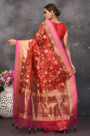 Buy this dazzling red kora silk handloom banarasi saree adorned with stunning resham and intricate Meenakari detailing along the border and pallu online in USA.  This Red color kora silk handloom Banarasi saree with pink-golden zari border in the comes with Unstitched blouse. Add this kora silk lace designer sari from Pure Elegance Indian fashion store in USA.- Back view with open pallu.