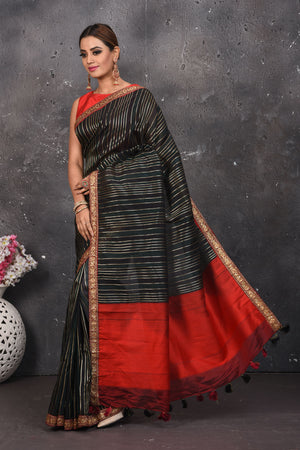 Buy this elegant black saree leheriya with gota patti work online in USA. Style this designer sari which has a beautiful red border with golden lace at the edge with a potli bag and high heels. Add designer gota patti sari to your collection from Pure Elegance Indian saree store in USA.- Full view.