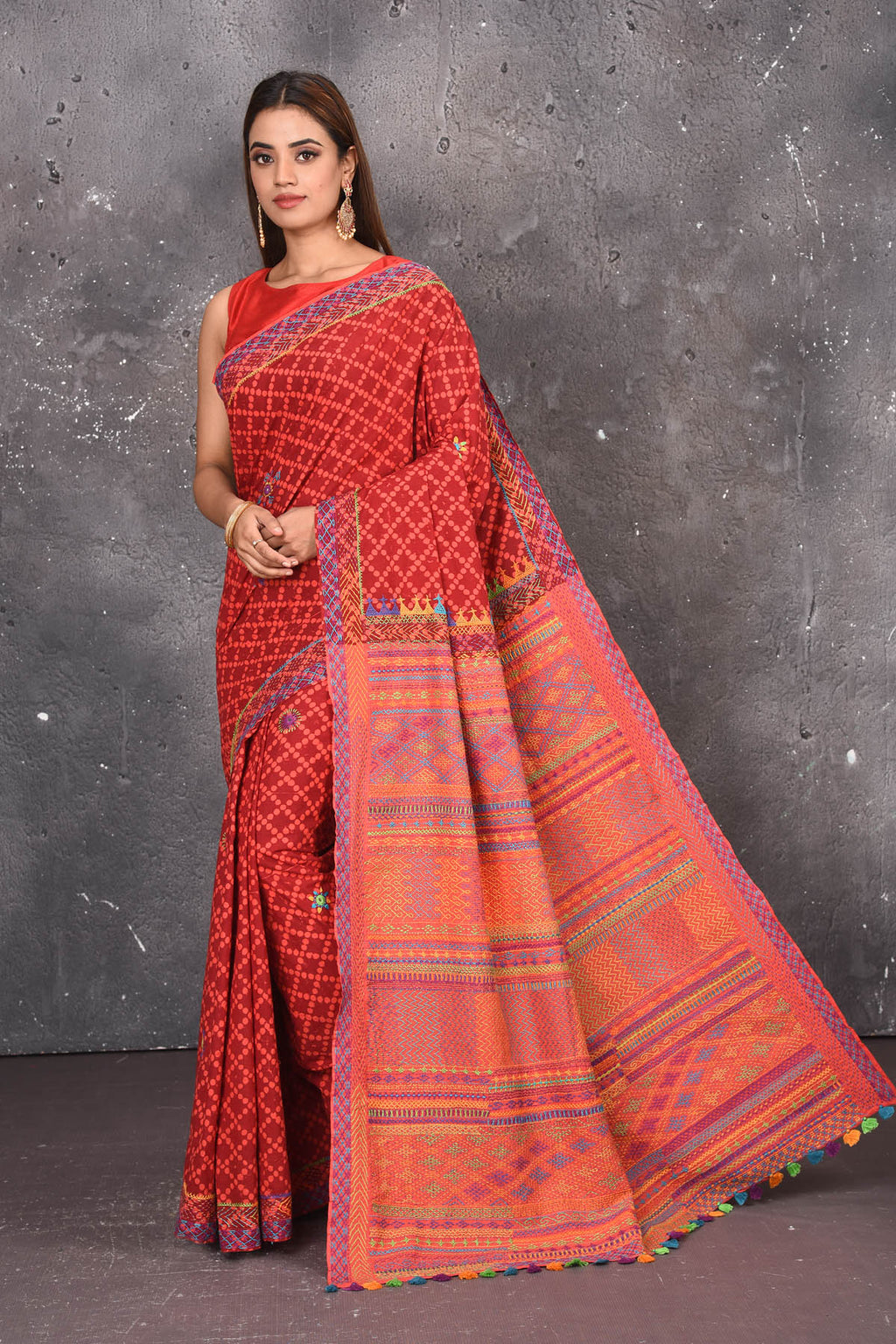 Shop this classy red hand painted madhubani cotton saree online in USA. Perfect to be worn as part of your everyday work wear, with this hand-painted red Madhubani saree, elegance meets traditional. Add this designer Lambani embroidery designer saree with colored tassels to your collection from Pure Elegance Indian Fashion Store in USA.- Full view.