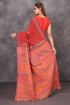 Shop this classy red hand painted madhubani cotton saree online in USA. Perfect to be worn as part of your everyday work wear, with this hand-painted red Madhubani saree, elegance meets traditional. Add this designer Lambani embroidery designer saree with colored tassels to your collection from Pure Elegance Indian Fashion Store in USA.- Back view with open pallu.