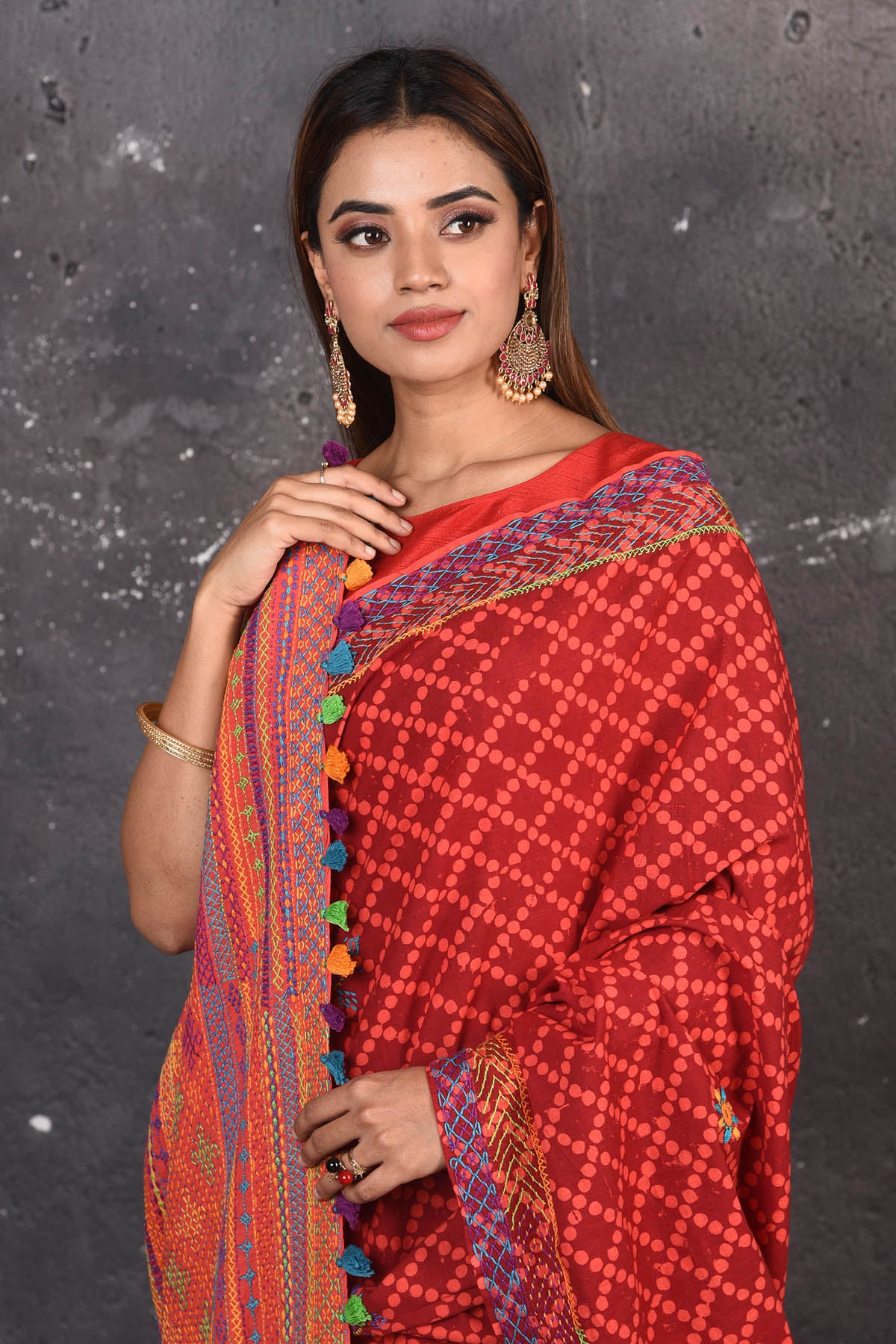 Shop this classy red hand painted madhubani cotton saree online in USA. Perfect to be worn as part of your everyday work wear, with this hand-painted red Madhubani saree, elegance meets traditional. Add this designer Lambani embroidery designer saree with colored tassels to your collection from Pure Elegance Indian Fashion Store in USA.- Close up.