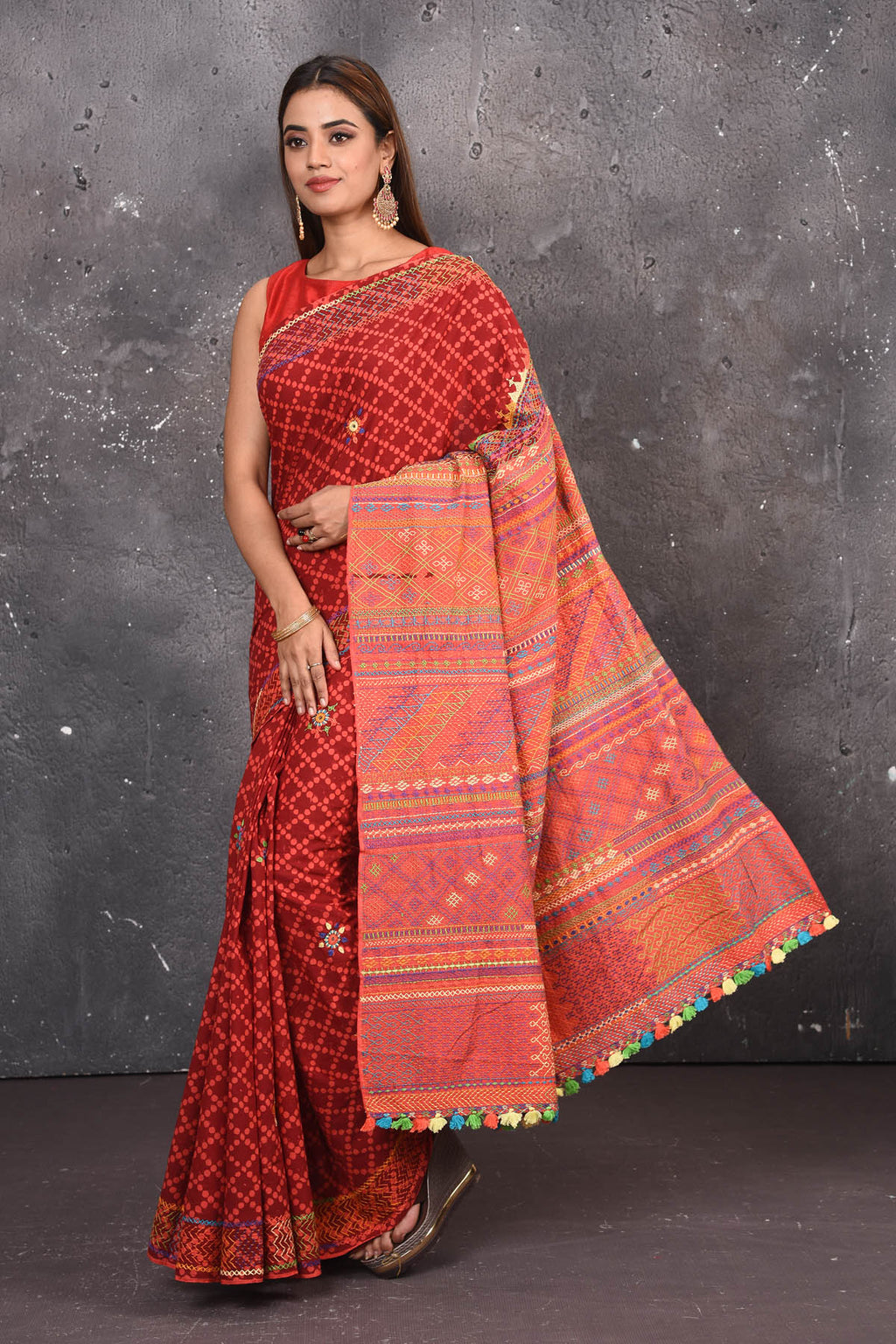 Shop this classy red hand painted madhubani cotton saree online in USA. Perfect to be worn as part of your everyday work wear, with this hand-painted red Madhubani saree, elegance meets traditional. Add this designer Lambani embroidery designer saree with colored tassels to your collection from Pure Elegance Indian Fashion Store in USA.- Full view with open pallu.