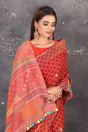 Shop this classy red hand painted madhubani cotton saree online in USA. Perfect to be worn as part of your everyday work wear, with this hand-painted red Madhubani saree, elegance meets traditional. Add this designer Lambani embroidery designer saree with colored tassels to your collection from Pure Elegance Indian Fashion Store in USA.- Close up with wrapped pallu.