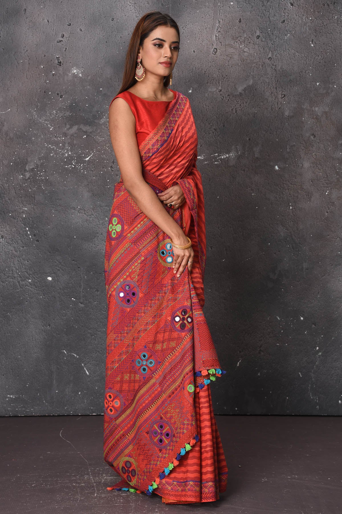 Buy this classy red hand painted madhubani cotton leheriya pattern saree online in USA. Perfect to be worn as part of your everyday work wear, with this hand-painted red Madhubani saree, elegance meets traditional. Add this designer Lambani embroidery designer saree with colored tassels to your collection from Pure Elegance Indian Fashion Store in USA.- Side view with wrapped pallu.