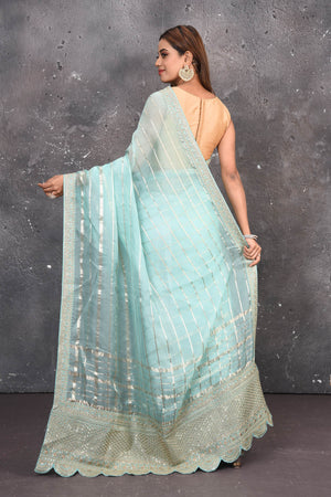 Buy this exquisite firozi blue saree in organza with striped print and silver embroidered border online in USA which is made of organza fabric and lightweight. This organza Saree is beautified with printed work and latest trend. Ideal for casual, kitty parties, stylish accessories. Shop this from Pure Elegance Indian fashion store in USA.-Back view with open pallu.
