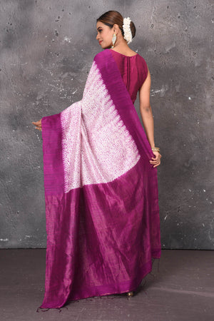 Shop this elegant offwhite-purple handloom shibori tussar saree online in USA which is handcrafted from fine silk tussar fabric, this tie and dye saree brings out the nature of flow. You can pair this beautiful shibori print with minimal jewellery for a casual day outfit. Add this plain shibori saree to your collection from Pure Elegance Indian fashion store in USA.- Back view with open pallu.