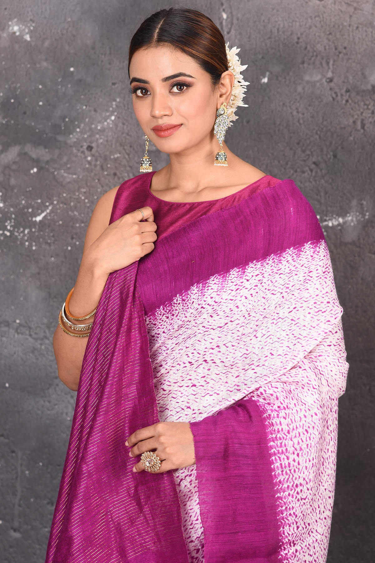 Shop this elegant offwhite-purple handloom shibori tussar saree online in USA which is handcrafted from fine silk tussar fabric, this tie and dye saree brings out the nature of flow. You can pair this beautiful shibori print with minimal jewellery for a casual day outfit. Add this plain shibori saree to your collection from Pure Elegance Indian fashion store in USA.- Close up.