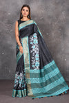 Shop this exquisite black pure tussar saree with firozi blue floral embroidered hand cutwork border online in USA which is handcrafted from fine silk tussar fabric, this tie and dye saree brings out the nature of flow. You can pair this beautiful floral embroidered print saree with minimal jewellery for a casual day outfit. Add this pure tussar saree to your collection from Pure Elegance Indian fashion store in USA.-Full view.
