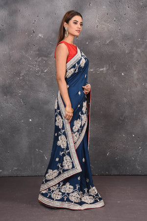 Buy this elegant navy blue gota patti mirror embroidered soft organza silk designer saree online in USA with colourful threadwork of flowers, gota patti leaves and dazzling cut dana and mirror work details. Mirror bootis are scattered all over the saree to match the brightness of the happy look. Add this designer sari to your collection from Pure Elegance Indian fashion store in USA.-Side view.