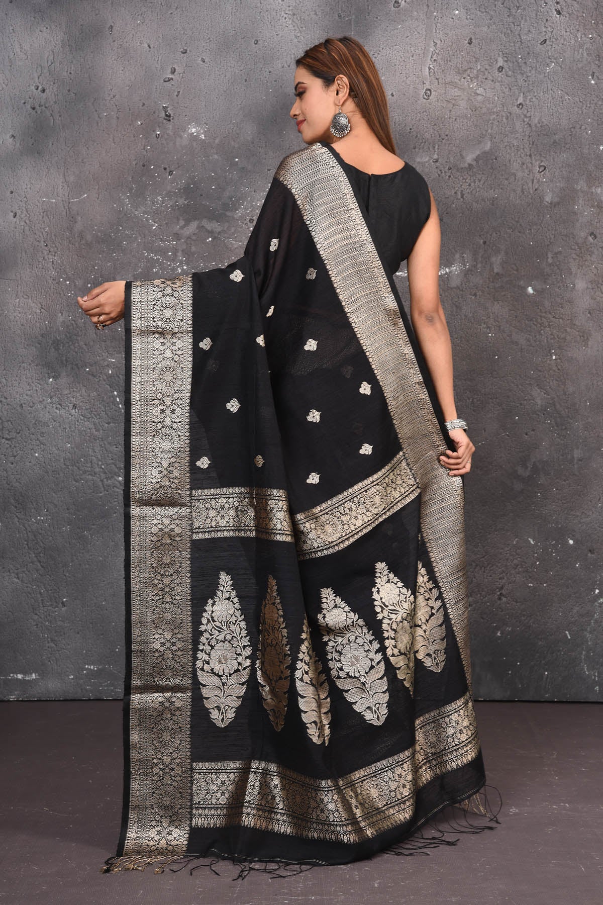 Buy elegant black zari woven matka Silk Banarasi saree with zari broad border online in USA which has crafted by skilled weaver of Banaras with elegance and grace, this saree is definitely the epitome of beauty and a must have in your collection. Buy designer handwoven banarasi brocade sari with any blouse from Pure Elegance Indian saree store in USA. -Back view with open pallu.