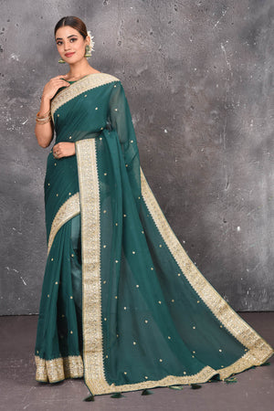 Buy exquisite pine green georgette banarasi designer saree with golden heavy Border online in USA which has crafted by skilled weaver of Banaras with elegance and grace, this saree is definitely the epitome of beauty and a must have in your collection. Buy designer handwoven banarasi georgette sari with any blouse from Pure Elegance Indian saree store in USA.-Full view with open pallu.