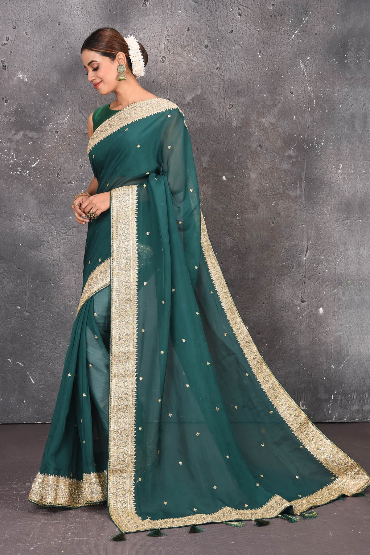 Buy exquisite pine green georgette banarasi designer saree with golden heavy Border online in USA which has crafted by skilled weaver of Banaras with elegance and grace, this saree is definitely the epitome of beauty and a must have in your collection. Buy designer handwoven banarasi georgette sari with any blouse from Pure Elegance Indian saree store in USA.-Side with open pallu.