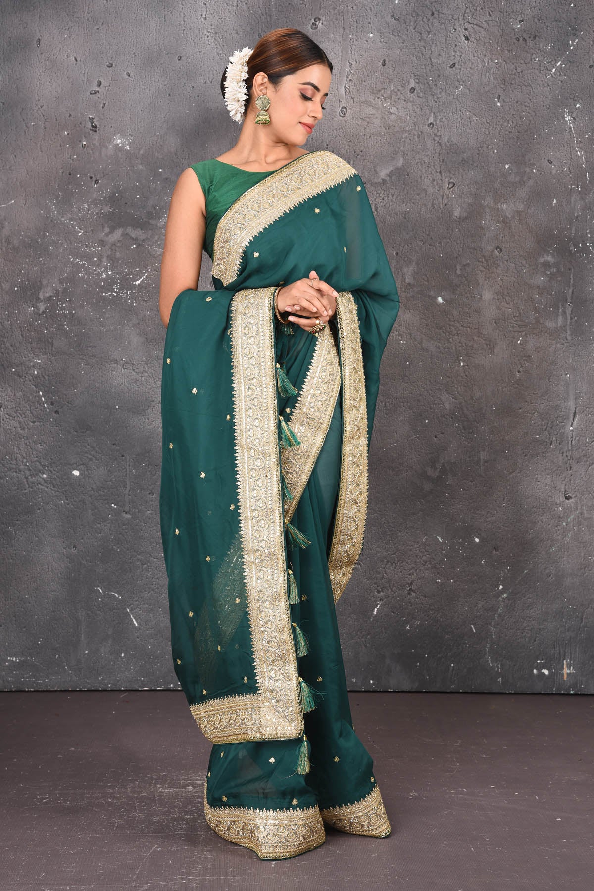 Buy exquisite pine green georgette banarasi designer saree with golden heavy Border online in USA which has crafted by skilled weaver of Banaras with elegance and grace, this saree is definitely the epitome of beauty and a must have in your collection. Buy designer handwoven banarasi georgette sari with any blouse from Pure Elegance Indian saree store in USA.-Front view.
