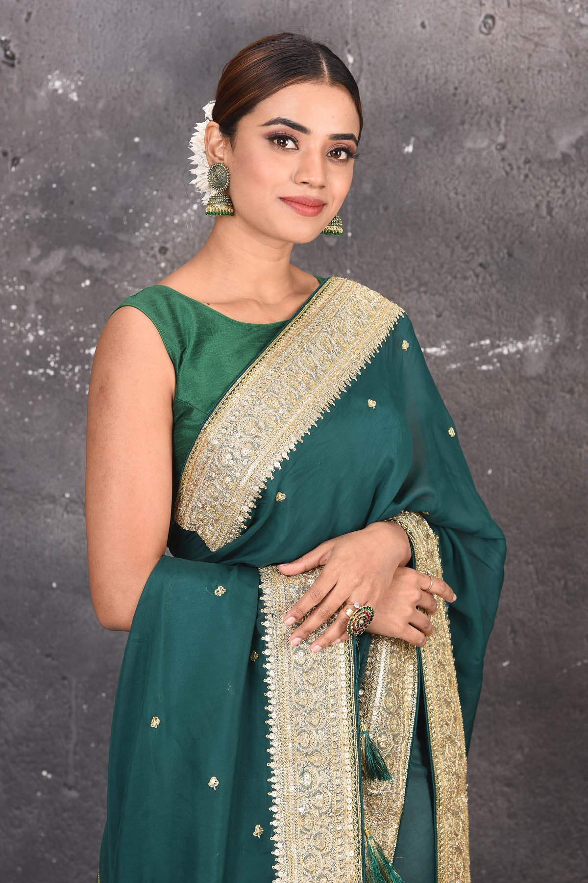 Buy exquisite pine green georgette banarasi designer saree with golden heavy Border online in USA which has crafted by skilled weaver of Banaras with elegance and grace, this saree is definitely the epitome of beauty and a must have in your collection. Buy designer handwoven banarasi georgette sari with any blouse from Pure Elegance Indian saree store in USA.-Close up.
