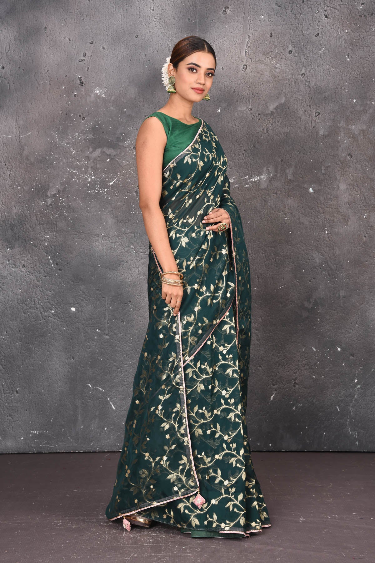 Buy exquisite dark green kora silk designer saree with floral jaal print online in USA. Pure kora sarees by Pure Elegance in green color. It has a beautiful floral jaal print all over. This kora brings the charm and simplicity of this saree with border and pallu. Shop this designer silk sari from Pure Elegance Indian fashion store in USA.-Side view.