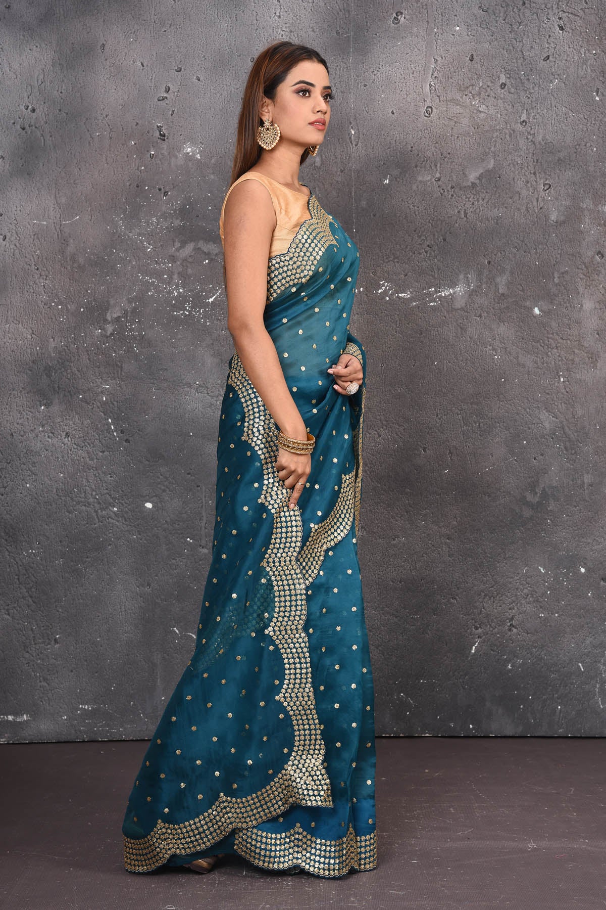 Buy exquisite blue organza saree with golden embroidered online in USA. Pure organza sarees by Pure Elegance in blue color. It has a beautiful gold embroidered border. This organza brings the charm and simplicity of this saree with border and pallu with the delegate embroidery work on border. Shop this designer silk sari from Pure Elegance Indian fashion store in USA.-Side view.