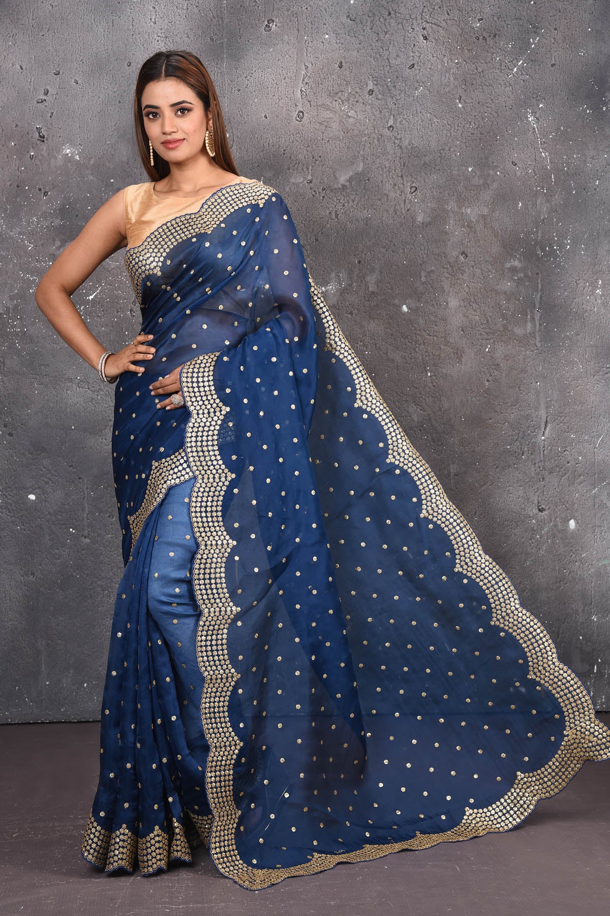 Buy exquisite navy blue organza saree with golden embroidered online in USA. Pure organza sarees by Pure Elegance in blue color. It has a beautiful gold embroidered border. This organza brings the charm and simplicity of this saree with border and pallu with the delegate embroidery work on border. Shop this designer silk sari from Pure Elegance Indian fashion store in USA.-Full view with open pallu.