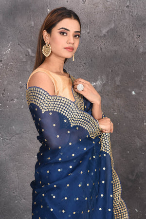 Buy exquisite navy blue organza saree with golden embroidered online in USA. Pure organza sarees by Pure Elegance in blue color. It has a beautiful gold embroidered border. This organza brings the charm and simplicity of this saree with border and pallu with the delegate embroidery work on border. Shop this designer silk sari from Pure Elegance Indian fashion store in USA.-Close up.