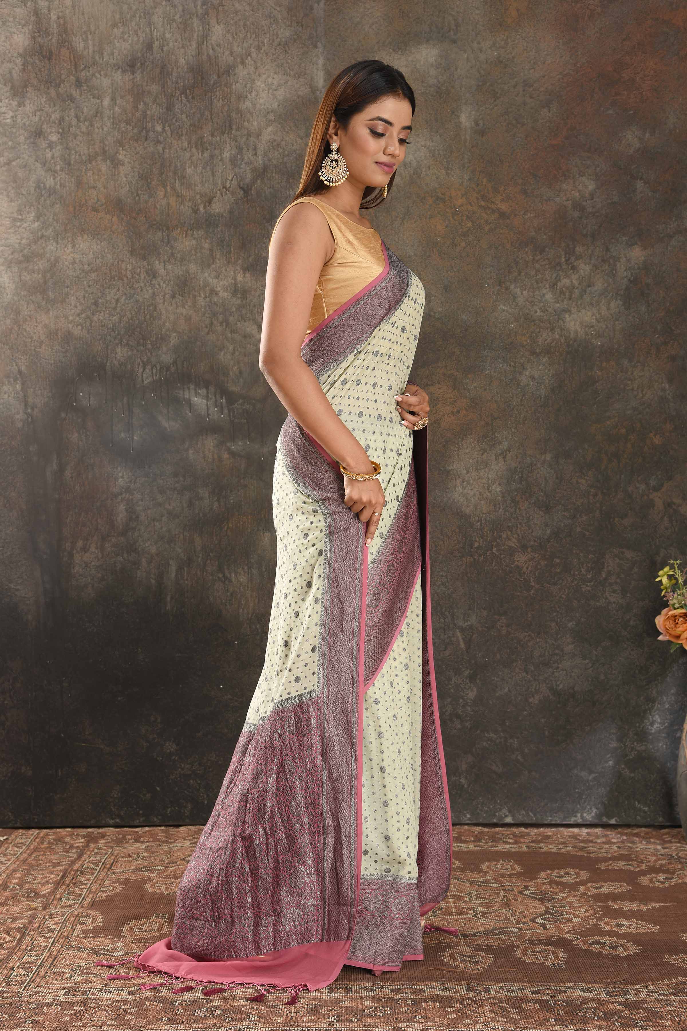 Shop stunning cream georgette sari online in USA with antique zari pink border. Be vision of elegance on special occasions in exquisite designer sarees, handwoven sarees, georgette sarees, embroidered sarees, Banarasi sarees from Pure Elegance Indian saree store in USA.-side