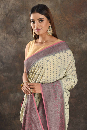 Shop stunning cream georgette sari online in USA with antique zari pink border. Be vision of elegance on special occasions in exquisite designer sarees, handwoven sarees, georgette sarees, embroidered sarees, Banarasi sarees from Pure Elegance Indian saree store in USA.-closeup