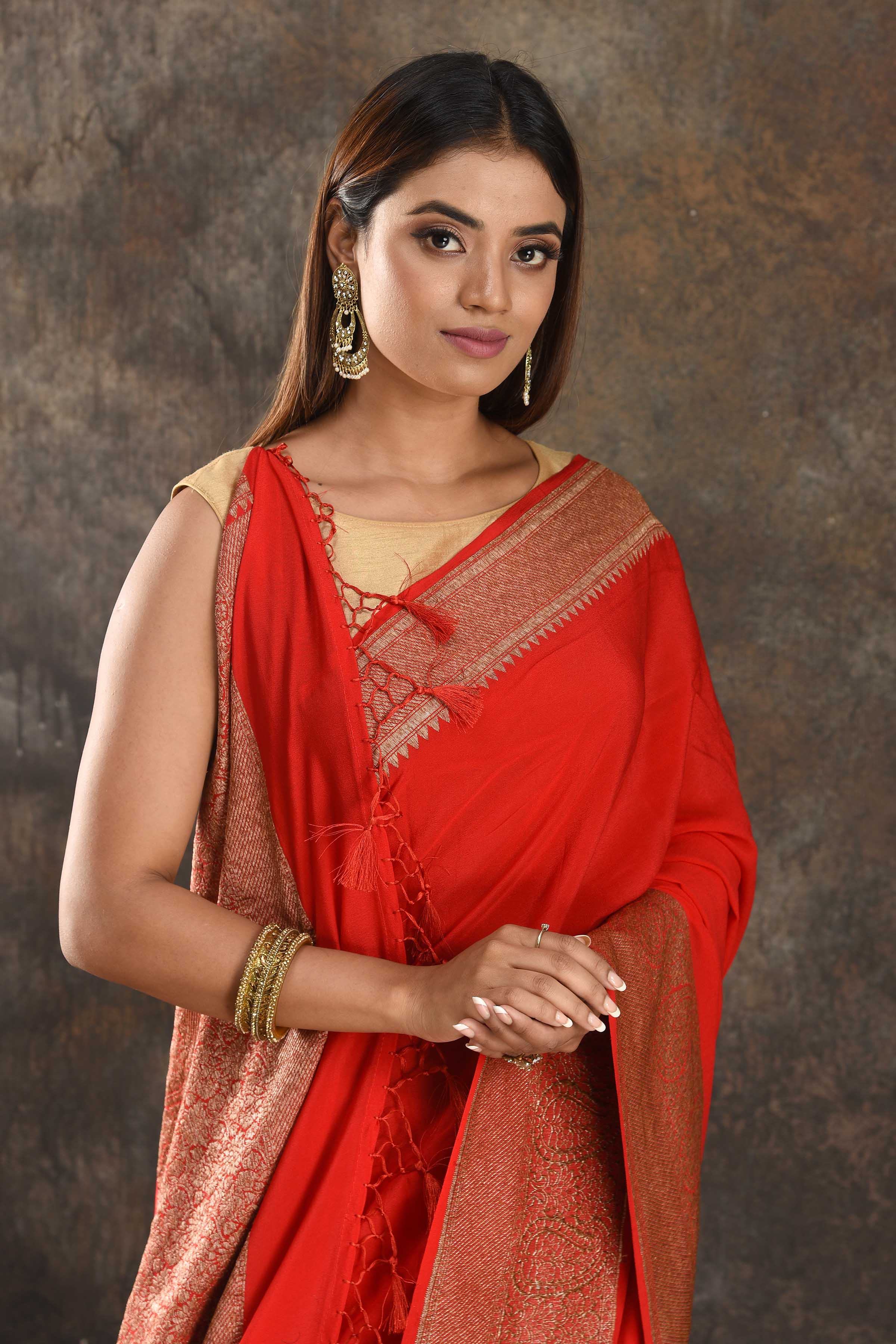 Shop stunning red crepe saree online in USA with zari border. Be vision of elegance on special occasions in exquisite designer sarees, handwoven sarees, georgette sarees, embroidered sarees, Banarasi sarees from Pure Elegance Indian saree store in USA.-closeup