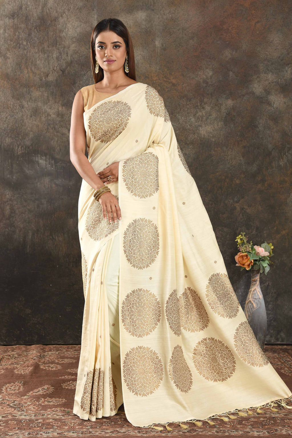 Buy beautiful cream Muga Banarasi saree online in USA with antique zari motifs. Be vision of elegance on special occasions in exquisite designer sarees, handwoven sarees, georgette sarees, embroidered sarees, Banarasi saree, pure silk saris from Pure Elegance Indian saree store in USA.-full view